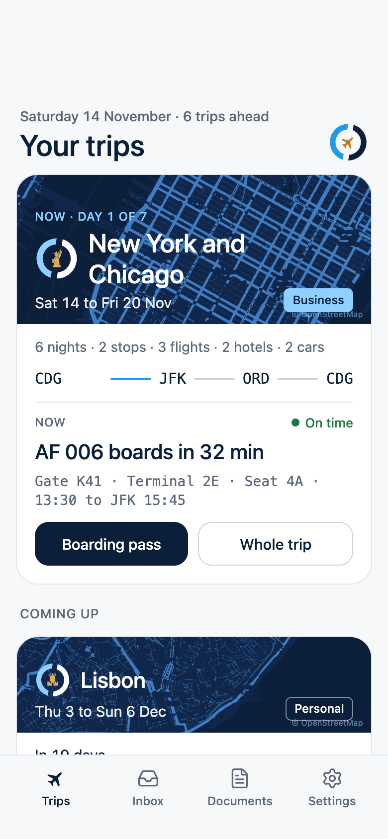The Trips screen: the current trip to New York and Chicago with its flight boarding in 32 minutes, then the coming trips as cards with city maps and dates.
